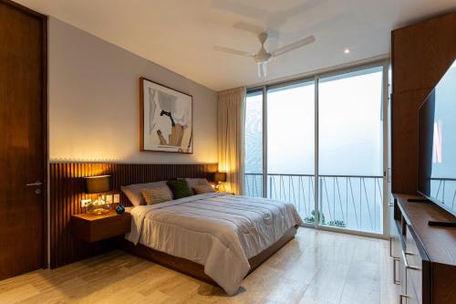 a bedroom with a bed and a large window at Casa del Paseo Luxury Home in Centro Rooftop Bar & 2 Pools in Mérida