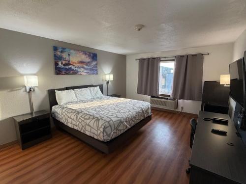 a bedroom with a bed and a desk and a television at Best Nights Hotel in Fond du Lac