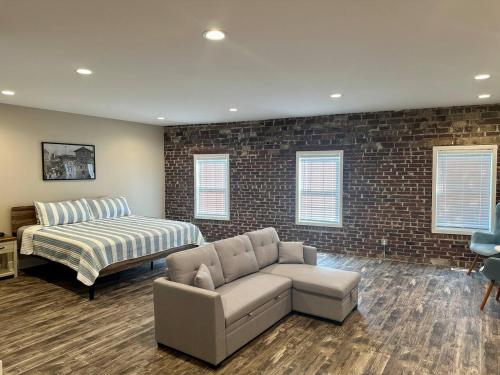 a living room with a couch and a bed at Mill View Suite - River Rock Inn in Bellevue