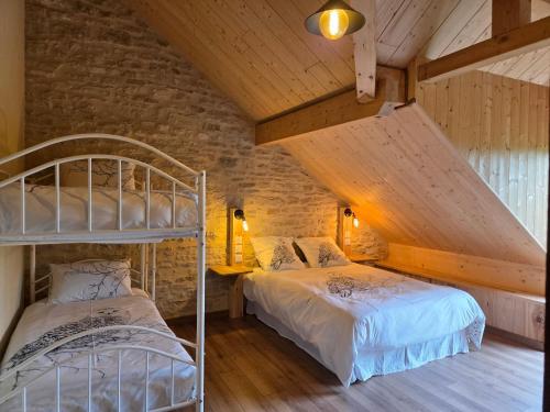 a bedroom with two bunk beds and a brick wall at La R'mise de Surcey in Alaise