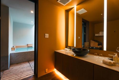 a bathroom with a sink and a large mirror at Boscage Kariya in Yugawara