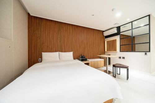 a bedroom with a large white bed and a table at Hotel Salmon in Seoul
