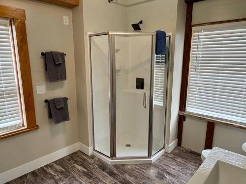 a shower stall in a bathroom with two windows at Paddle Wheel Suite-Potter’s Mill in Bellevue