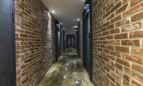 an alleyway with a brick wall and a waterway at Hotel H2 in Ulsan