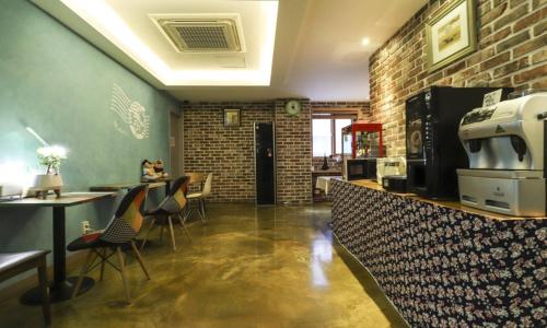 a restaurant with a bar with chairs and a brick wall at Hotel H2 in Ulsan
