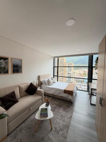 a living room with a couch and a bed at Diseño, vistas Monserrate WiFi 300Mb in Bogotá