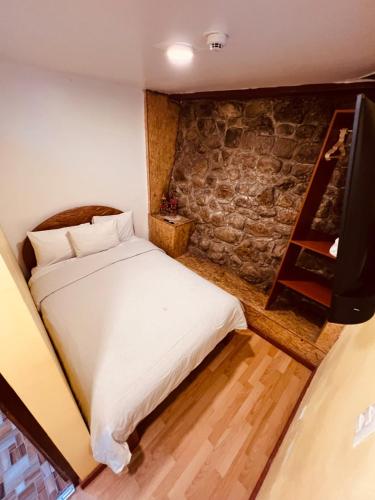 a bedroom with a bed and a tv in it at PAKARI Wasi in Cusco