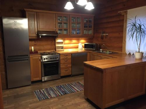a kitchen with stainless steel appliances and wooden cabinets at Isakaru Puhkemaja in Otepää