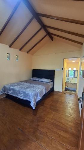 a bedroom with a bed in a room with wooden floors at SleepHere Homestay in Bayan