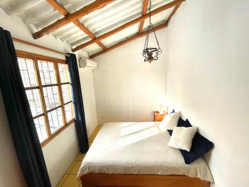a bedroom with a bed in a room with windows at Black&White Brüäder in Puerto Ayora