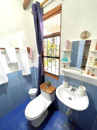 a bathroom with a toilet and a sink and a window at Black&White Brüäder in Puerto Ayora
