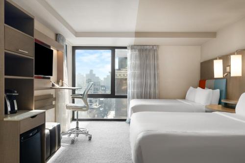 a hotel room with two beds and a large window at EVEN Hotel Brooklyn by IHG in Brooklyn