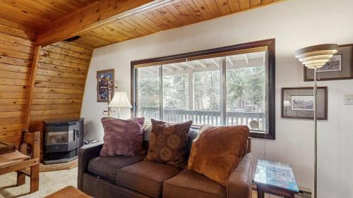 a living room with a couch and a window at Cozy A-Frame Cabin in Downtown McCall in McCall