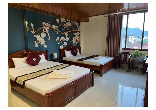a bedroom with two beds and a wall with flowers at Ngan Nga in Bắc Hà