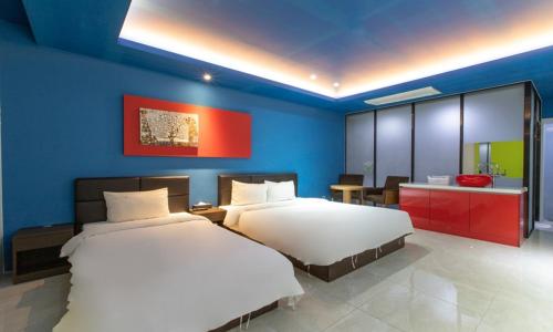 two beds in a bedroom with a blue wall at Incheon Pentastar Hotel in Incheon