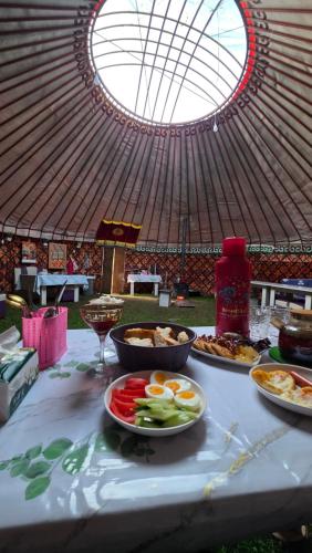 a table with plates of food on top of it at Emin Sky Camp in Mineralʼnyy Istochnik Altyn-Arasan