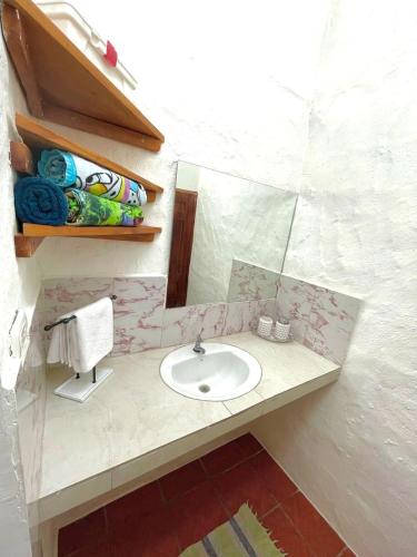 a bathroom with a sink and a mirror at BLACK&WHITE -Dis Dihai- in Puerto Ayora