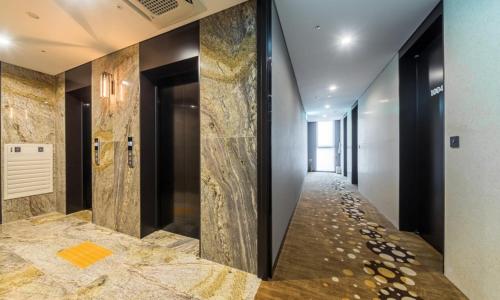 a corridor of a hotel with marble floors and walls at Dobong Hotel Bay204 in Seoul