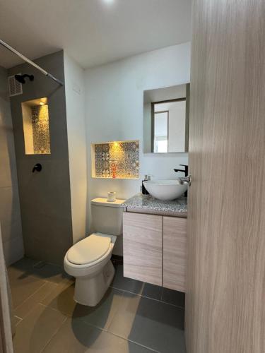a bathroom with a white toilet and a sink at Barranquilla Prime Apartment in Barranquilla