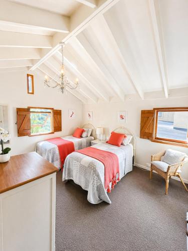 a bedroom with two beds and a chandelier at Eirene Retreat - Quiet Riverside Escape in Upper Hutt