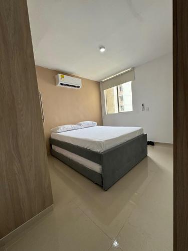 a bedroom with a bed and a window at Barranquilla Prime Apartment in Barranquilla