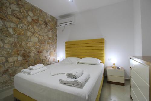 a bedroom with a large bed with towels on it at Pigeon Cave Apartments in Ksamil