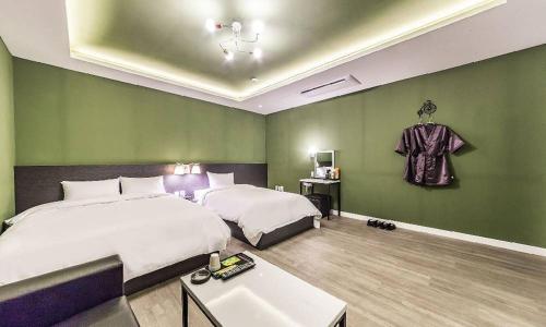a hotel room with two beds and a hanging shirt at Chuncheon Hotel View in Chuncheon