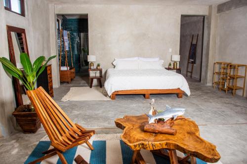 a bedroom with a bed and a table and chairs at La Familia Casa and Suites in Holbox Island