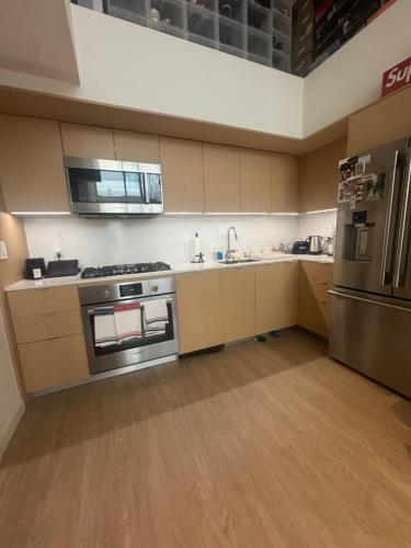 an empty kitchen with a stove and a refrigerator at Luxury Loft 1BR Steps Away from Santa Monica Pier in Los Angeles