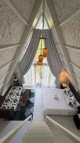 a attic bedroom with two beds and a window at Cabin Corazon in Coron