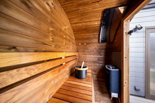 a sauna with wooden walls and a trash can at KomoreNest伊豆熱川 in Higashiizu