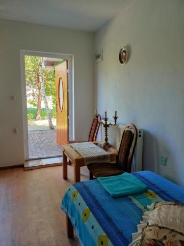 a bedroom with a bed and a table and a door at Pensjonat agroturystyczny Sosnówka - KOSARZYN in Kosarzyn