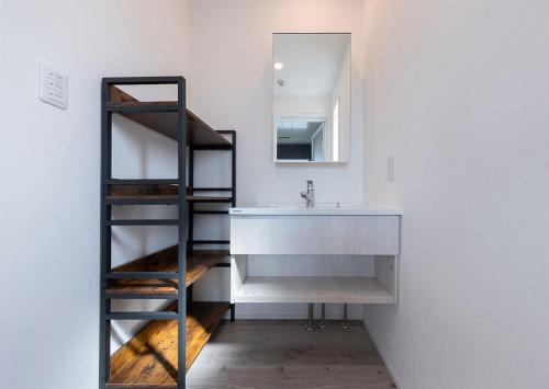 a bathroom with a sink and a mirror at Tabinoteitaku Y-beach in Tsuruoka