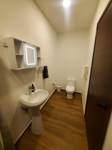 a bathroom with a sink and a toilet at hermoso departamento totalmente equipado ,céntrico, aberca, elevador , estacionamiento privado in Mazatlán