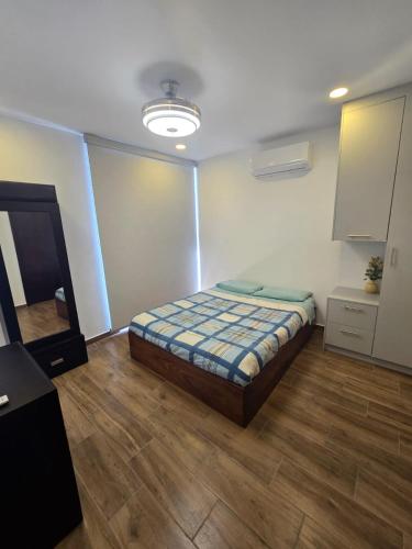 a bedroom with a bed in the middle of the room at hermoso departamento totalmente equipado ,céntrico, aberca, elevador , estacionamiento privado in Mazatlán