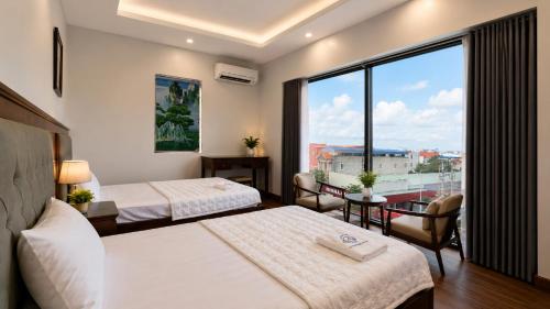 a hotel room with two beds and a large window at Moonland Hotel in Phương Lăng