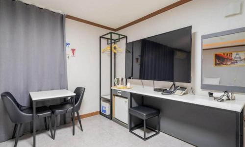 a room with a desk and chairs in a room at Donghae Gloria Hotel in Donghae