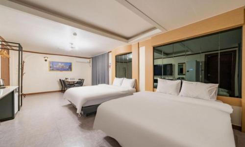 a hotel room with two beds and a table at Donghae Gloria Hotel in Donghae
