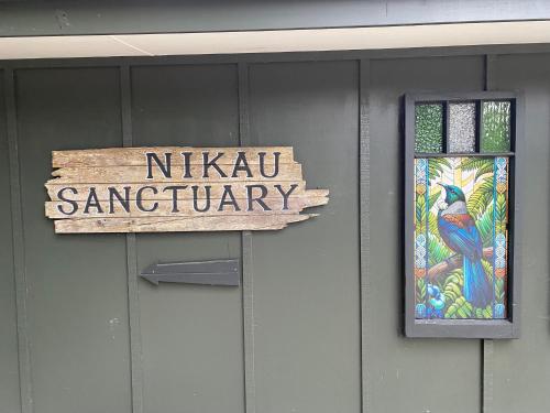 a sign and a stained glass window on a building at Nikau Sanctuary in Raglan