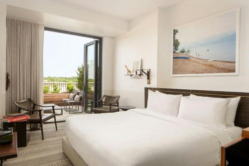 a hotel room with a bed and a balcony at Halcyon, a hotel in Cherry Creek, Denver in Denver