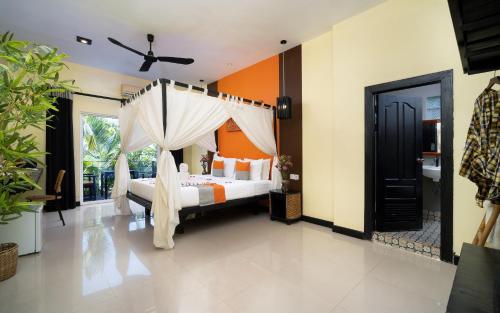 a bedroom with a bed with a mosquito net at Home Indochine d'Angkor Hotel in Siem Reap