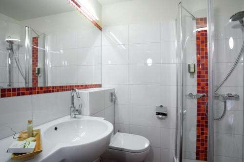 a bathroom with a sink and a toilet and a shower at Familienhotel Lagant in Brand
