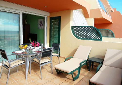 taras ze stołem i krzesłami na balkonie w obiekcie Luxury Apartment Balcon de Jandía w mieście Morro del Jable