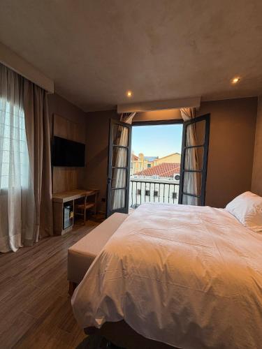 a bedroom with a large bed and a large window at Chateau Montchenot in Maipú