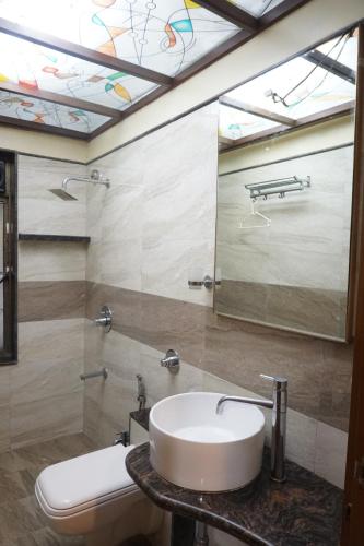 a bathroom with a sink and a mirror at S R Rooms in Pune