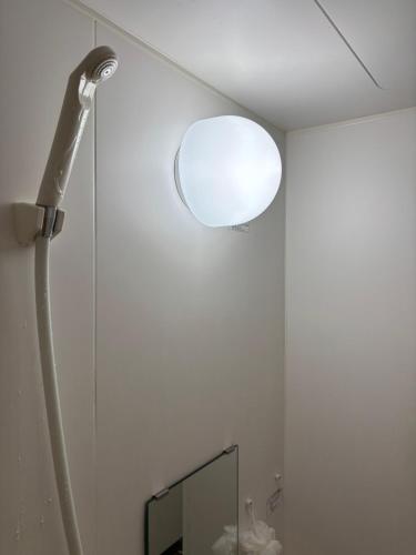 a bathroom with a light on the ceiling and a mirror at mixed room kiyamatiゲストハウスバックパッカー向け高齢の方宿泊不可 in Kyoto