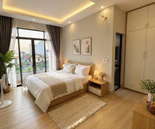 a bedroom with a large bed and a large window at Pi Home in Dong Hoi