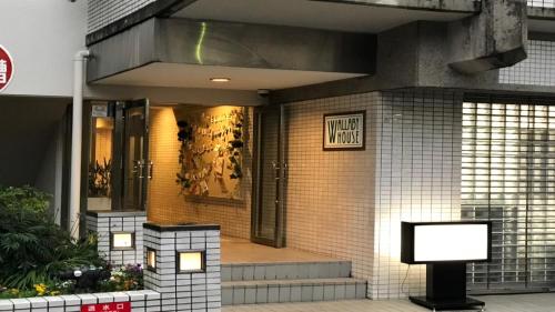 a front door of a building with a sign on it at Wallaby House in Kawaguchi
