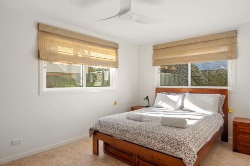 a bedroom with a bed and two windows at Free night! Pay for 2 stay for 3 in Mollymook