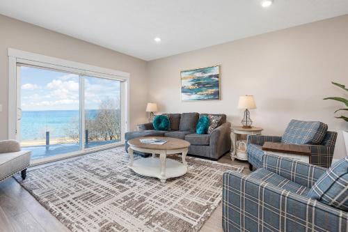 a living room with a couch and chairs and a large window at 539 Bay St ⁀➷ 3BDR Lake View Penthouse Condo on West Bay ➠ 401W in Traverse City
